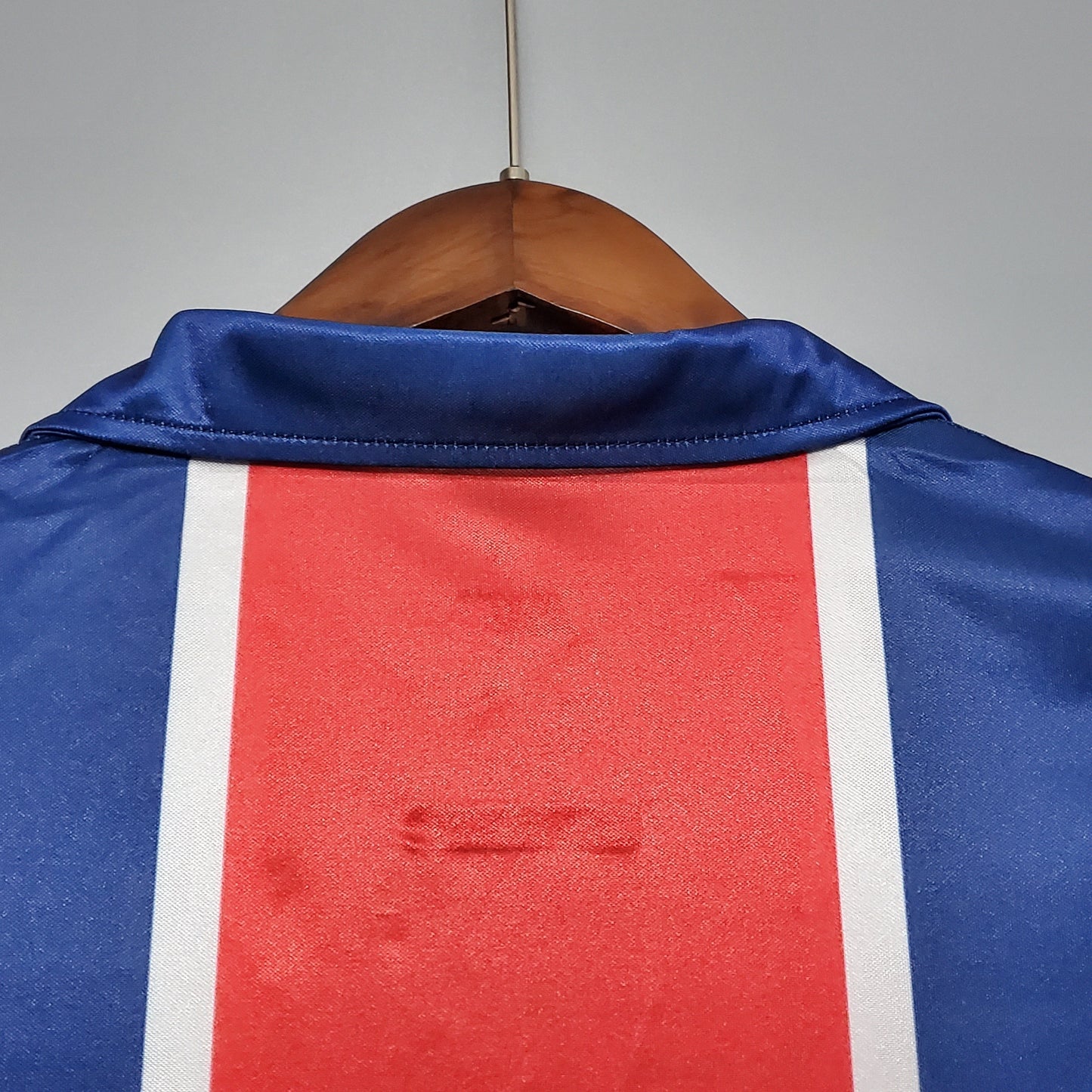 Detalle de camiseta de fútbol europea azul con franja roja y blanca, Reino del Futbol
