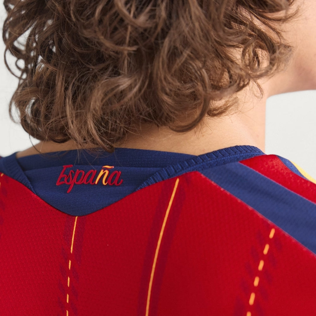 Detalle de la camiseta roja de la selección España 2026, texto España en el cuello, Reino del Futbol