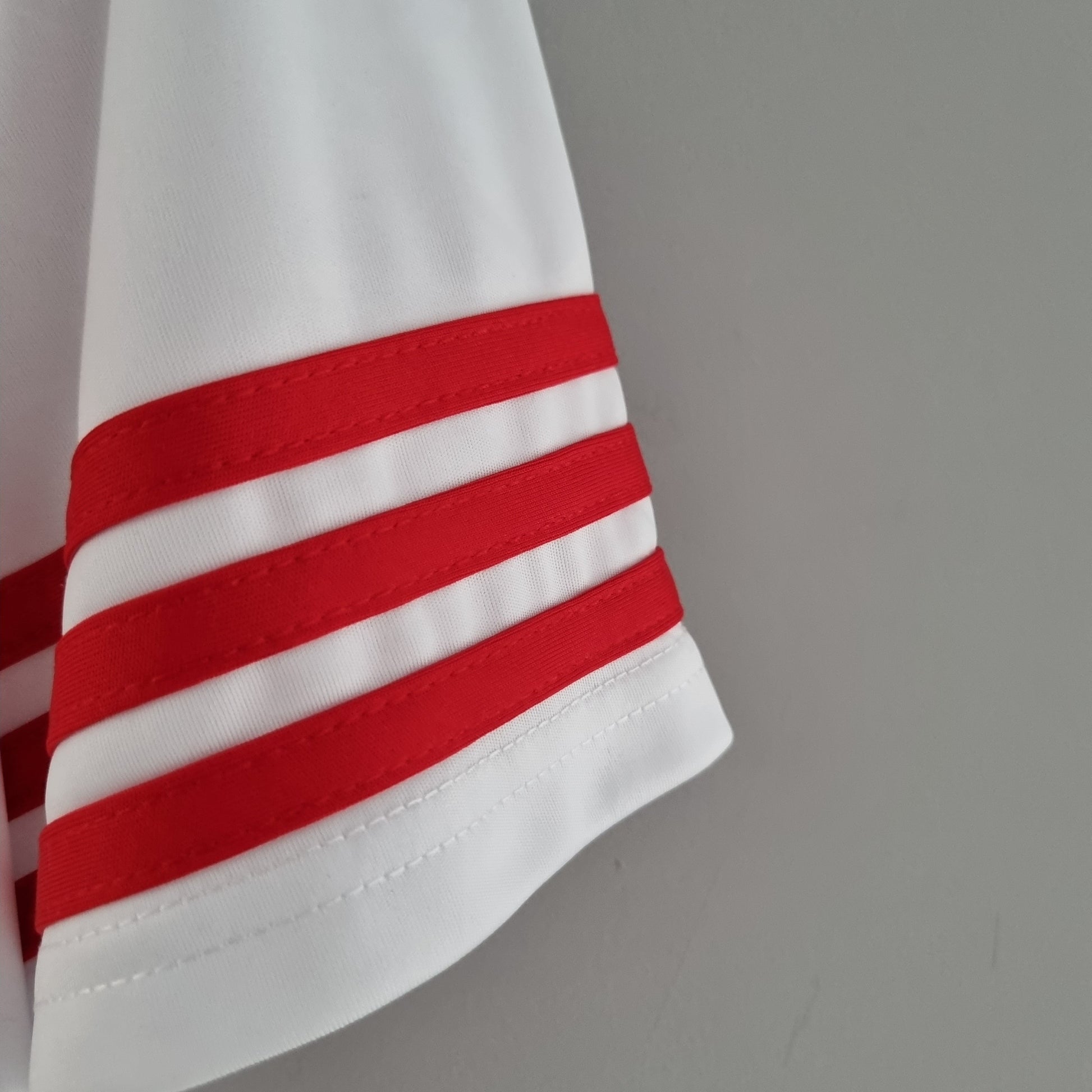 Detalle manga camiseta de fútbol blanca con tres franjas rojas, Reino del Futbol