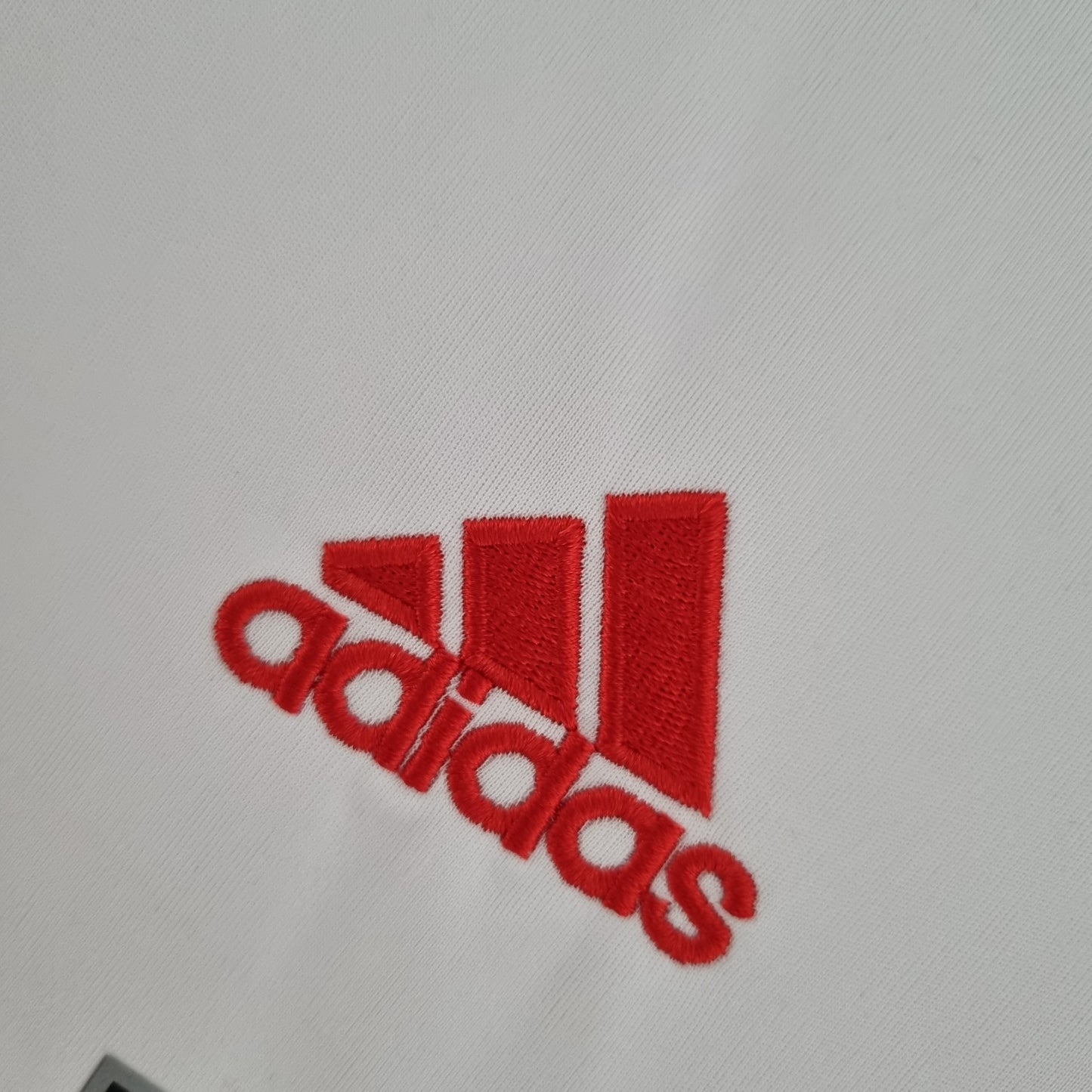 Logo Adidas rojo bordado en camiseta de fútbol blanca, Reino del Futbol tienda online