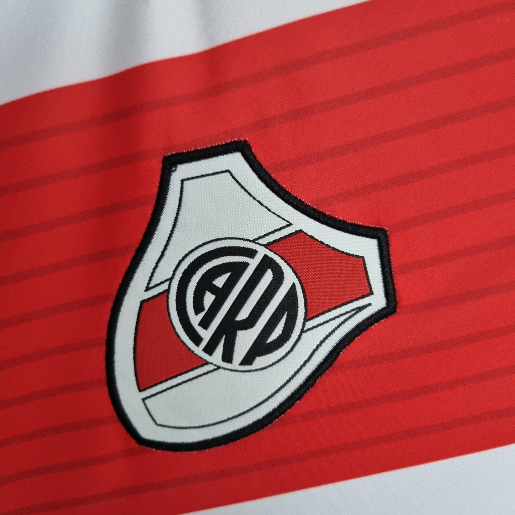 Escudo del River Plate en camiseta roja y blanca, tienda Reino del Futbol