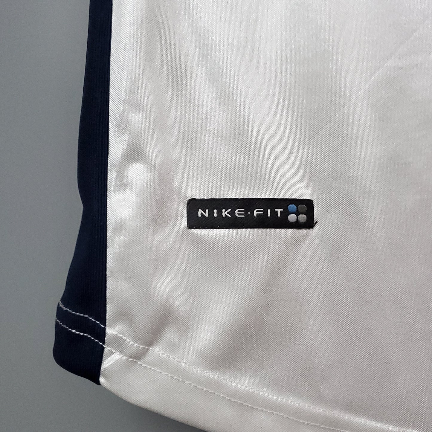 Detalle camiseta de fútbol europea Nike-Fit blanca con borde azul, Reino del Futbol