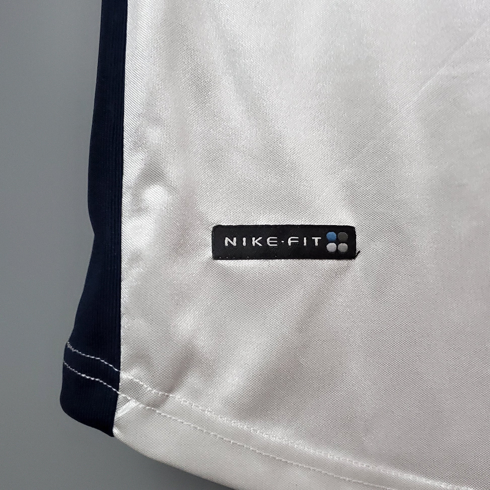 Detalle camiseta de fútbol europea Nike-Fit blanca con borde azul, Reino del Futbol