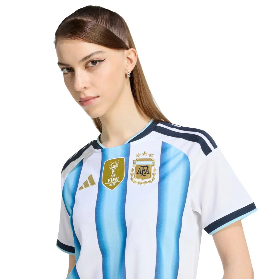 Mujer con camiseta Argentina 2026, escudo AFA y logo FIFA, Reino del Futbol