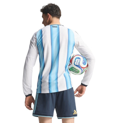 Camiseta Argentina 2026 manga larga, vista trasera, hombre sosteniendo balón FIFA, Reino del Futbol