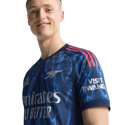 Camiseta Arsenal visitante 25/26 azul con rayos, logo y detalles rojos, Reino del Futbol