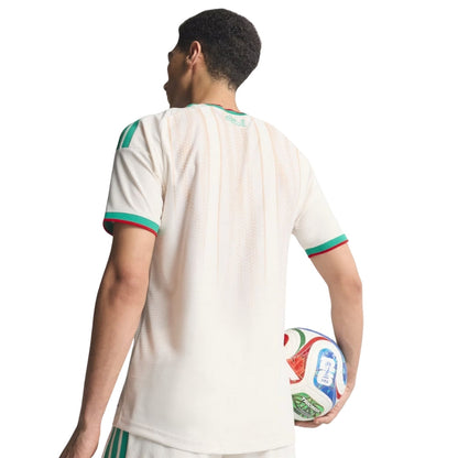 Jugador de fútbol con camiseta blanca de Argelia y balón oficial del Mundial, fondo blanco.