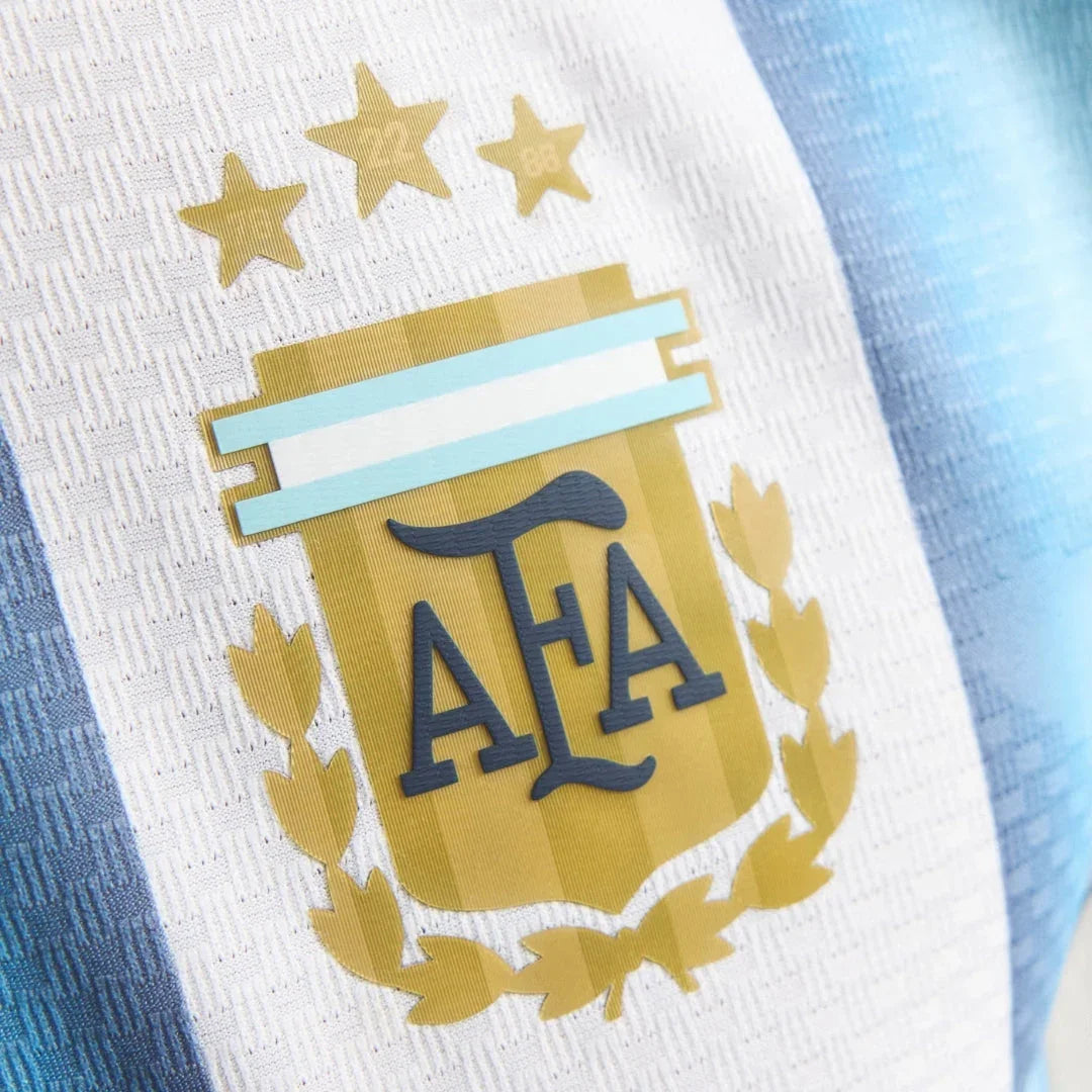 Detalle del escudo AFA en la camiseta de Argentina 2026, rayas celestes y blancas, Reino del Futbol