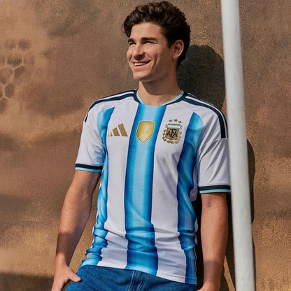 Hombre con camiseta Argentina 2026 local, diseño azul y blanco, junto a pared, Reino del Futbol