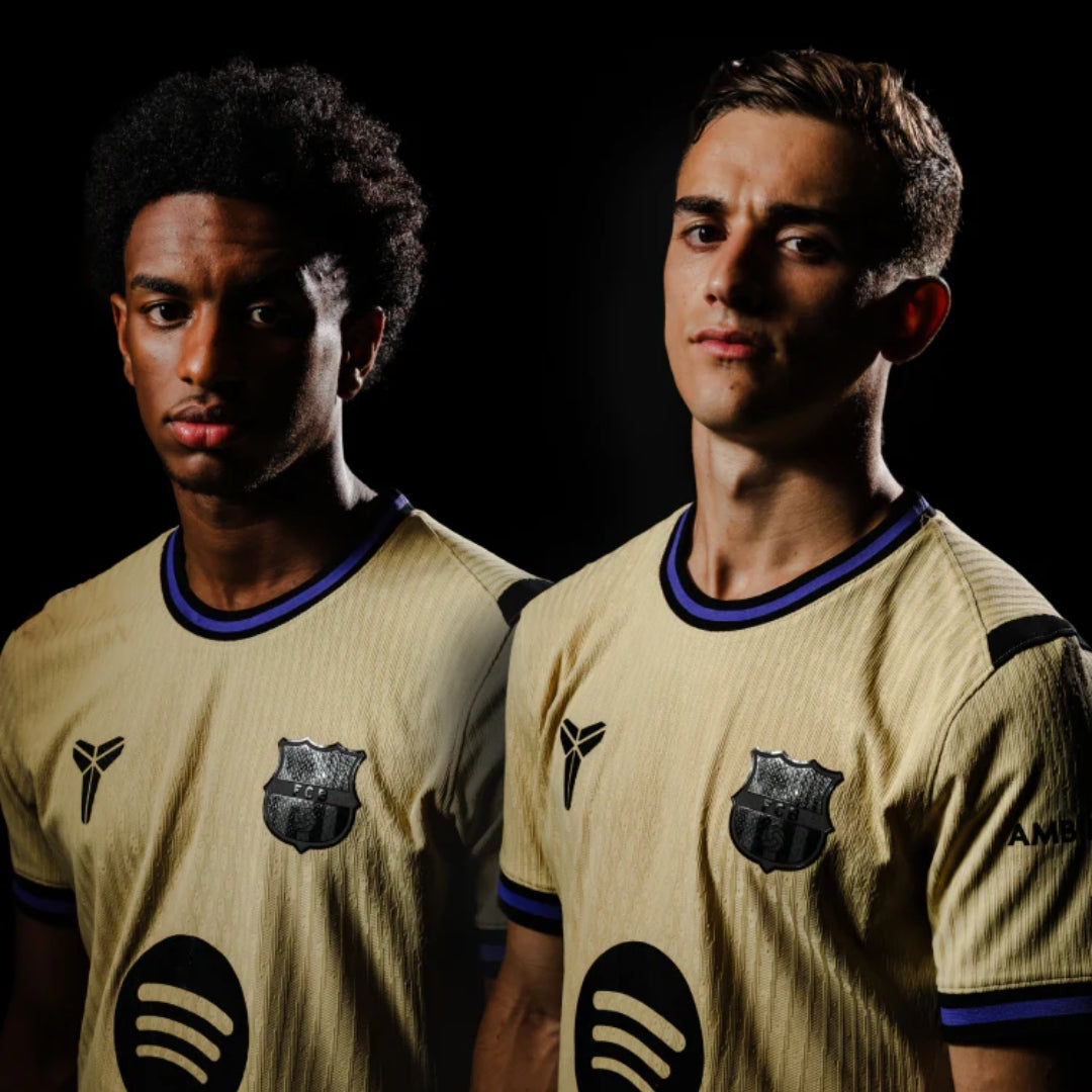 Jugadores con camiseta Barcelona dorada 2024, escudo FC Barcelona y logo Spotify, fondo negro.