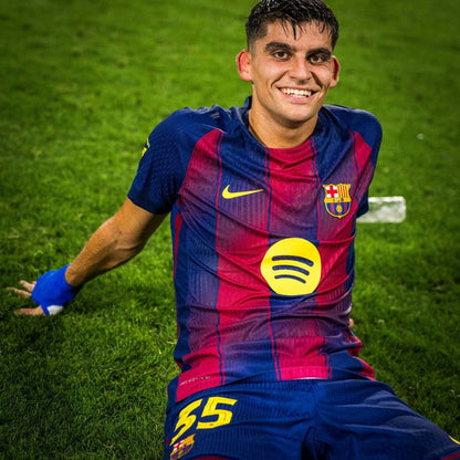 Jugador del Barcelona con camiseta azulgrana 2024, sentado en césped, Reino del Futbol