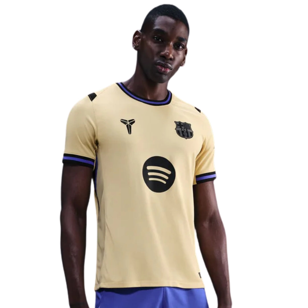 Camiseta Barcelona away 25/26 color dorado con logo Spotify, futbolista posando