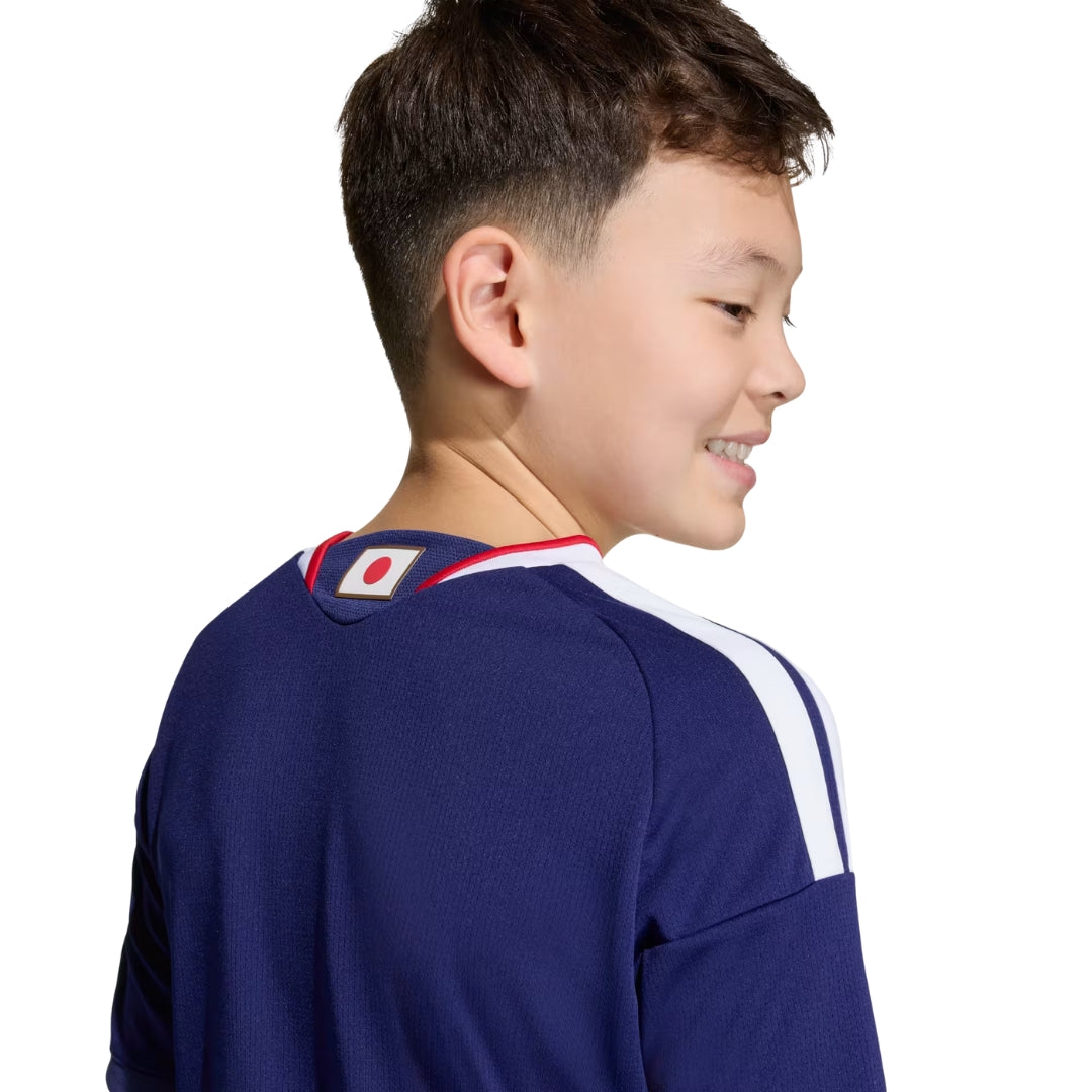 Niño con camiseta primera equipación Japón 2026 2027, color azul, bandera japonesa en el cuello