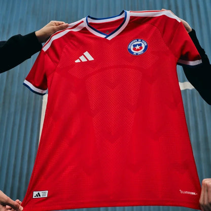 Camiseta roja oficial selección Chile adidas, logo Federación, fondo azul, Reino del Futbol