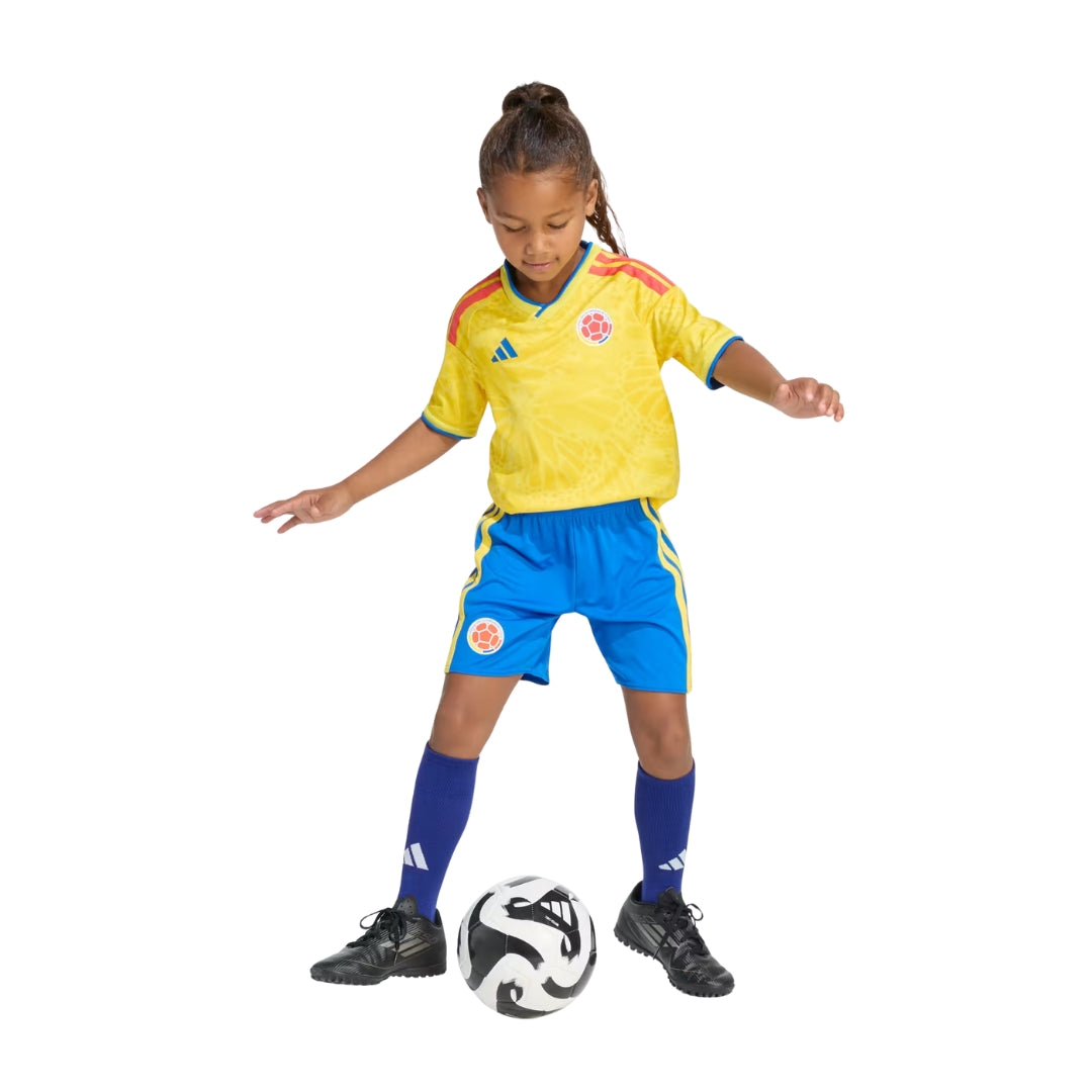 Niña con uniforme de fútbol Colombia 2026 para niños, Reino del Futbol, jugando con balón