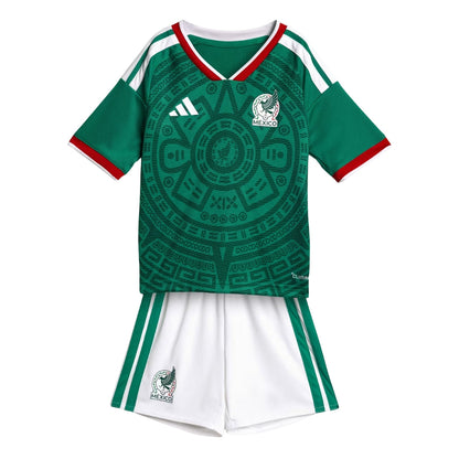 Conjunto local infantil de la Selección Nacional de México, camiseta verde con diseño azteca y shorts blancos.