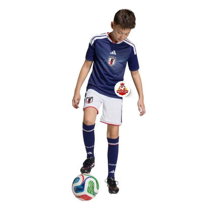 Niño con uniforme de fútbol Japón, balón y logo Reino del Futbol