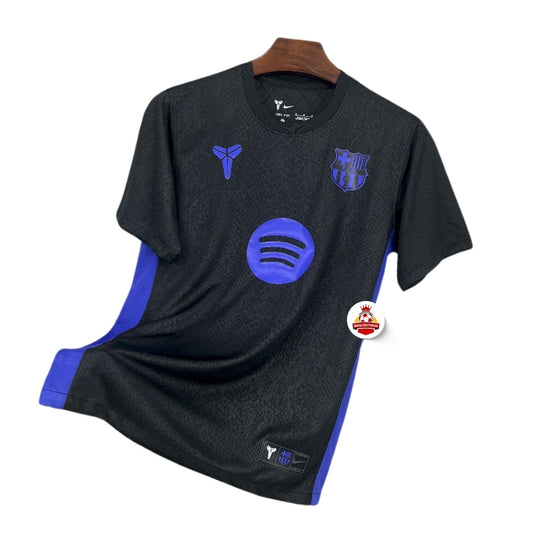 Camiseta de fútbol negra y azul del FC Barcelona con logos de Nike y Spotify, fondo blanco.