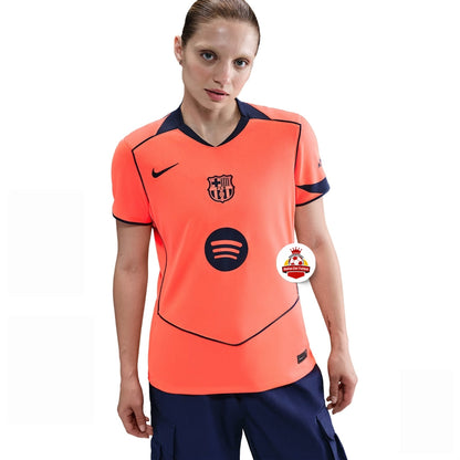 Mujer con camiseta naranja del FC Barcelona, logo Nike y Spotify, fondo blanco, Reino del Futbol