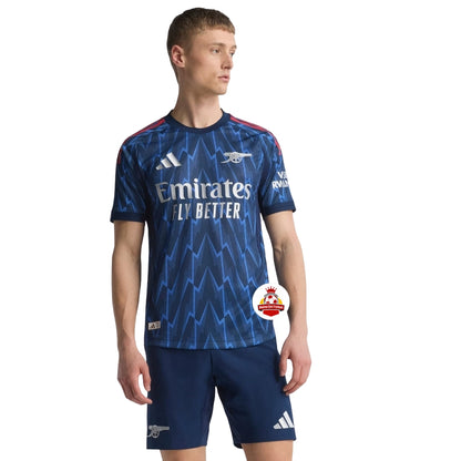 Camiseta azul Arsenal 2024 Adidas, diseño zigzag, modelo de pie, Reino del Futbol