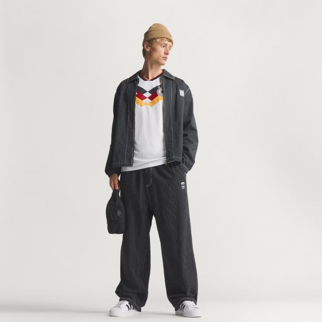 Hombre con camiseta de fútbol Alemania, pantalón y chaqueta a rayas, moda urbana Reino del Futbol