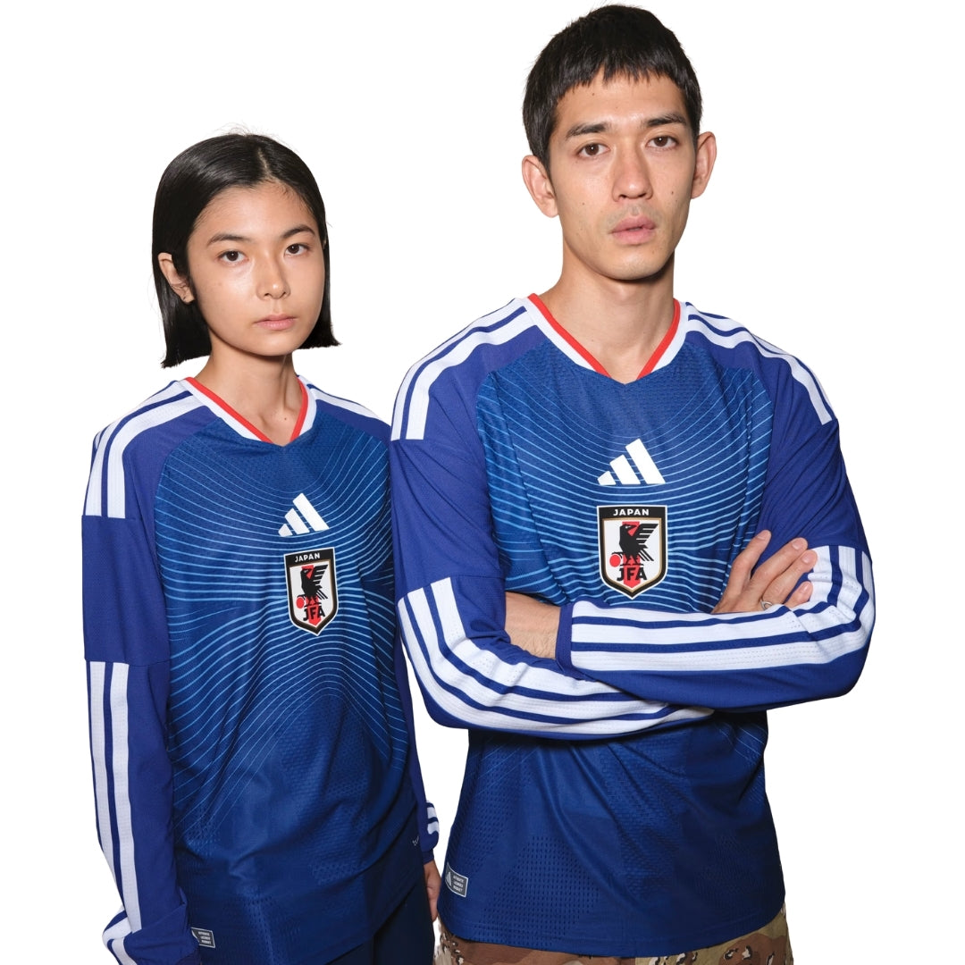 Dos personas con camiseta larga azul de la selección Japón 2026, Reino del Futbol