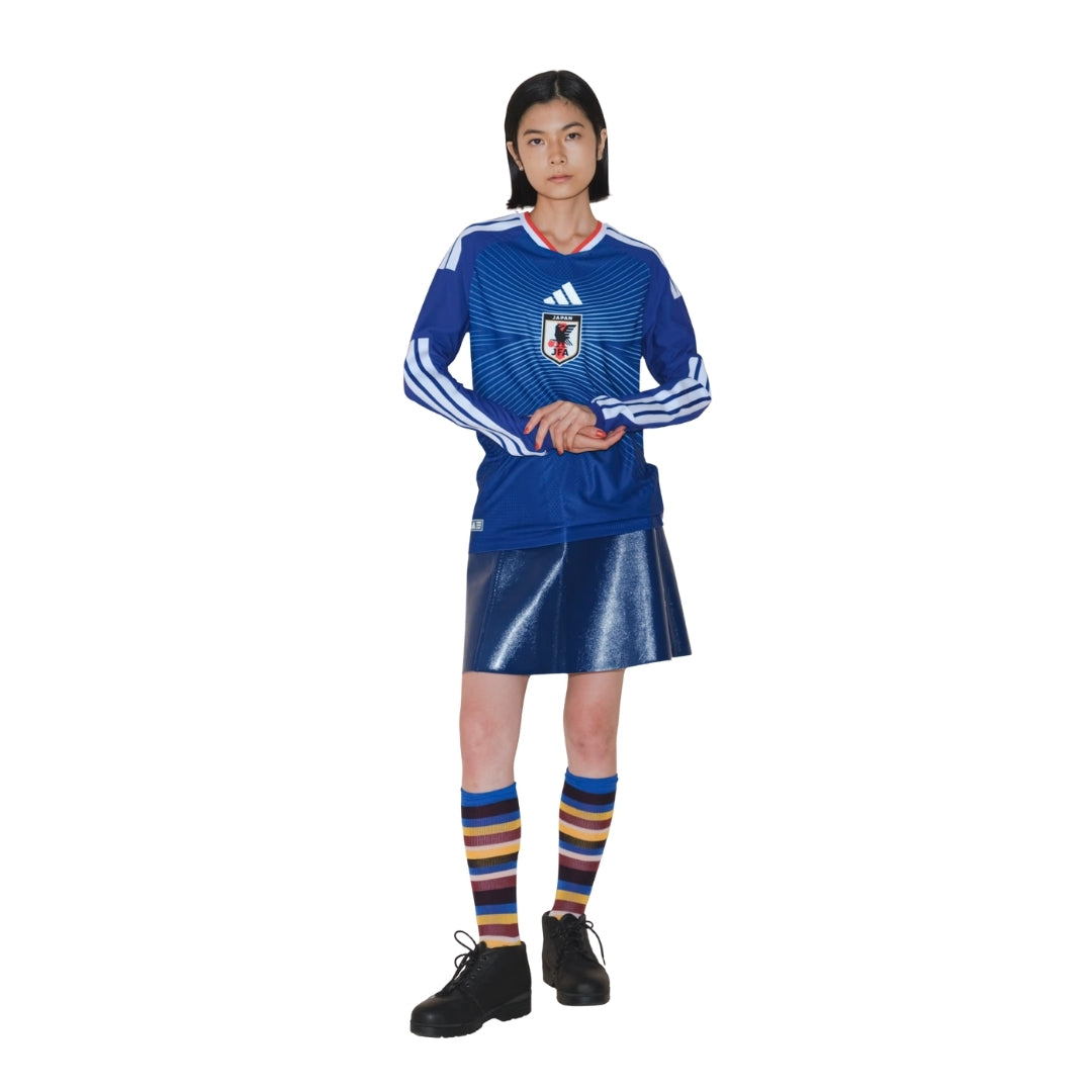 Mujer con camiseta de fútbol Japón 2026 manga larga, falda azul y calcetas rayadas, Reino del Futbol