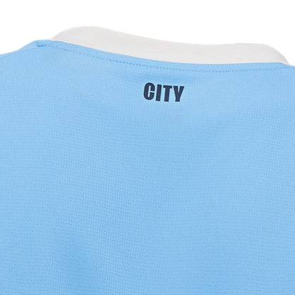 Detalle de la camiseta Manchester City local azul claro con texto CITY en la espalda, Reino del Futbol