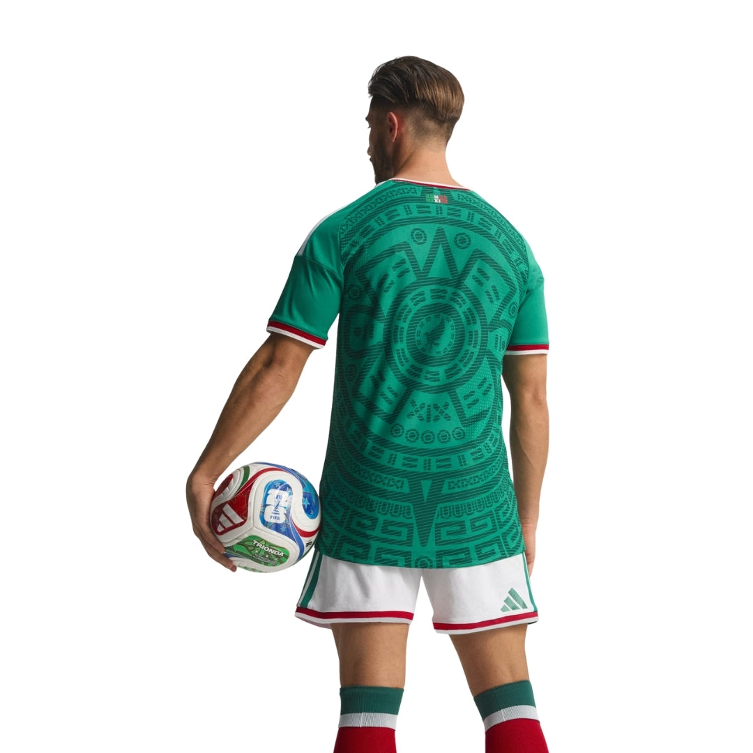 Jugador con uniforme verde México 2026, balón de futbol, fondo blanco, Reino del Futbol