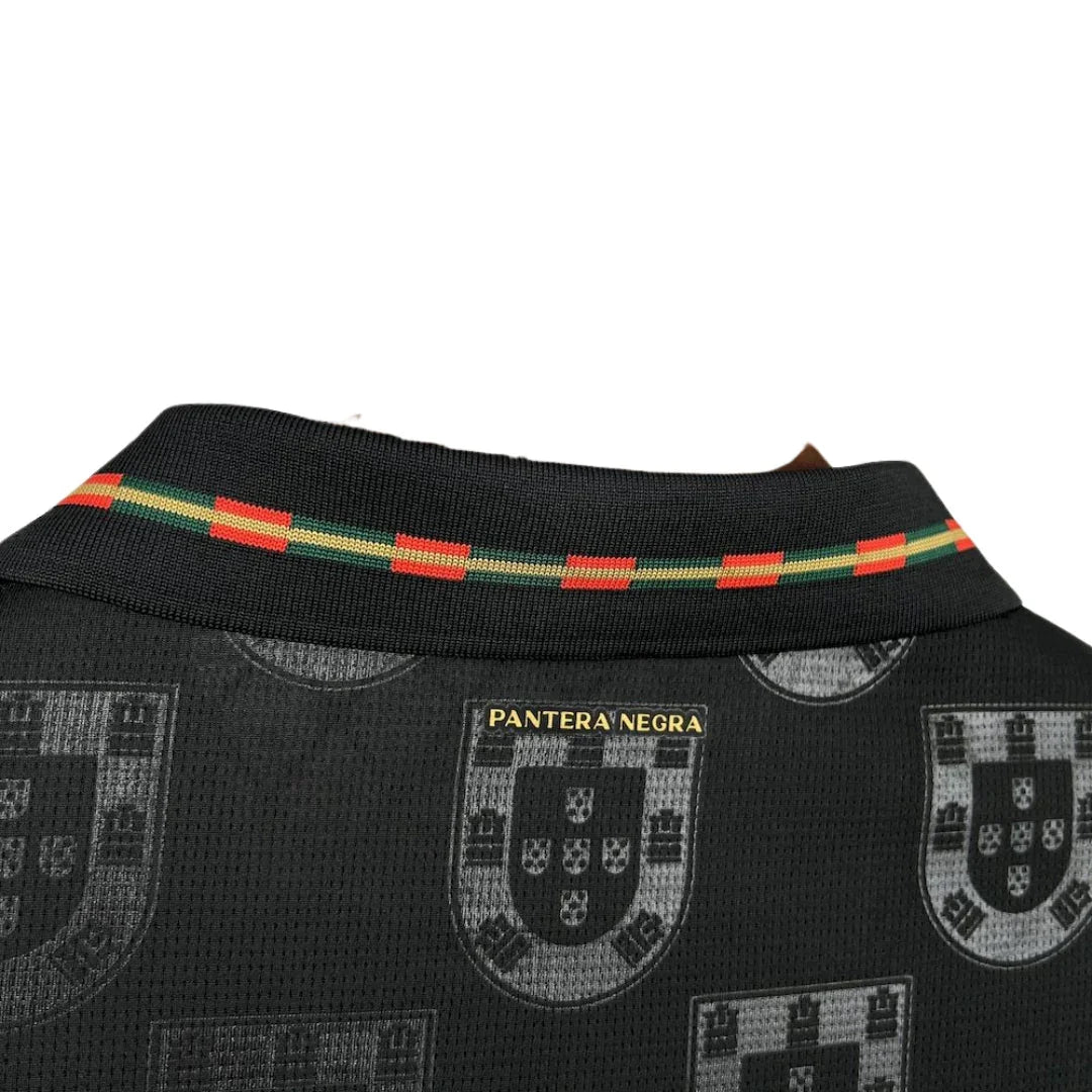 Detalle de cuello de camiseta negra Portugal Pantera Negra con escudos y banda tricolor futbol