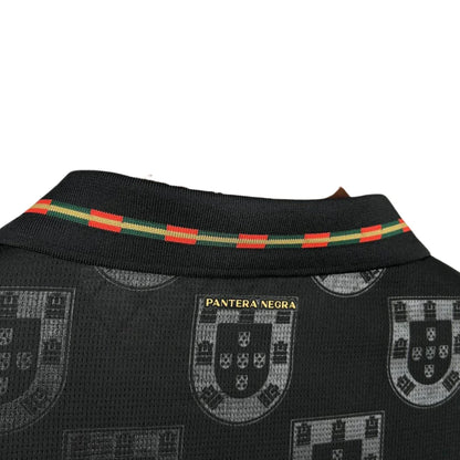 Detalle de cuello de camiseta negra Portugal Pantera Negra con escudos y banda tricolor futbol
