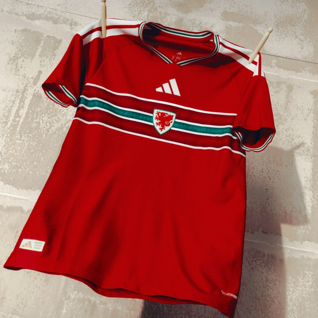 Camiseta roja de la selección de Gales para la Copa Mundial 2026, escudo y detalles verdes, Reino del Futbol.