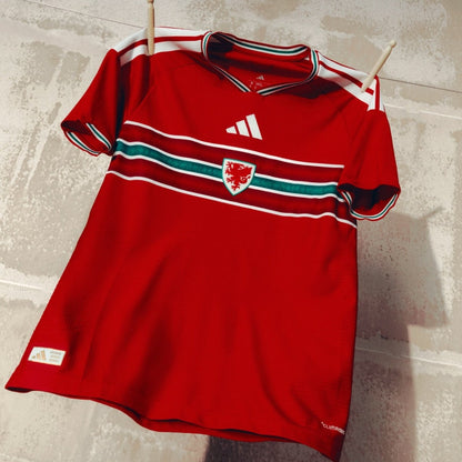 Camiseta roja de la selección de Gales para la Copa Mundial 2026, escudo y detalles verdes, Reino del Futbol.