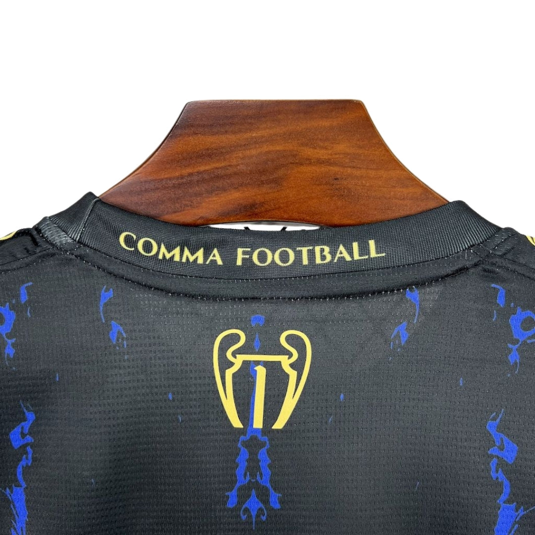 Detalle de la parte posterior de camiseta de fútbol negra con detalles azules y dorados, texto 'COMMA FOOTBALL', venta en Reino del Futbol.