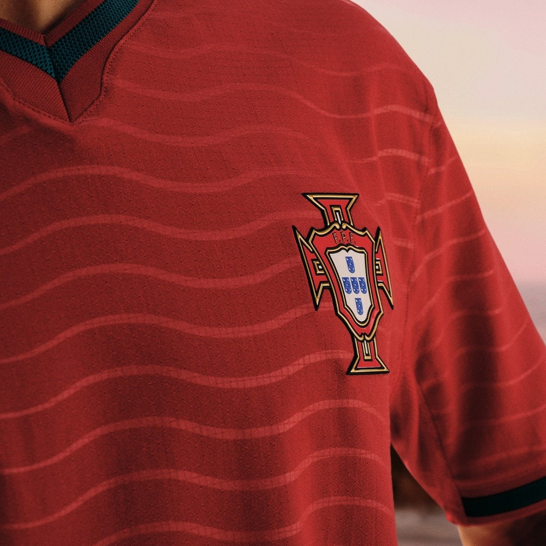 Camiseta de fútbol Portugal 2026 roja con escudo, fondo desenfocado, Reino del Futbol