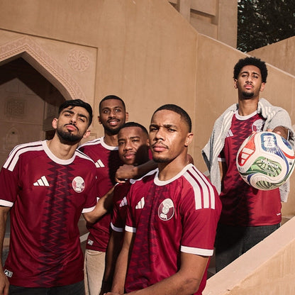 Jugadores con camiseta de fútbol Qatar 2026, balón y arquitectura árabe, Reino del Futbol