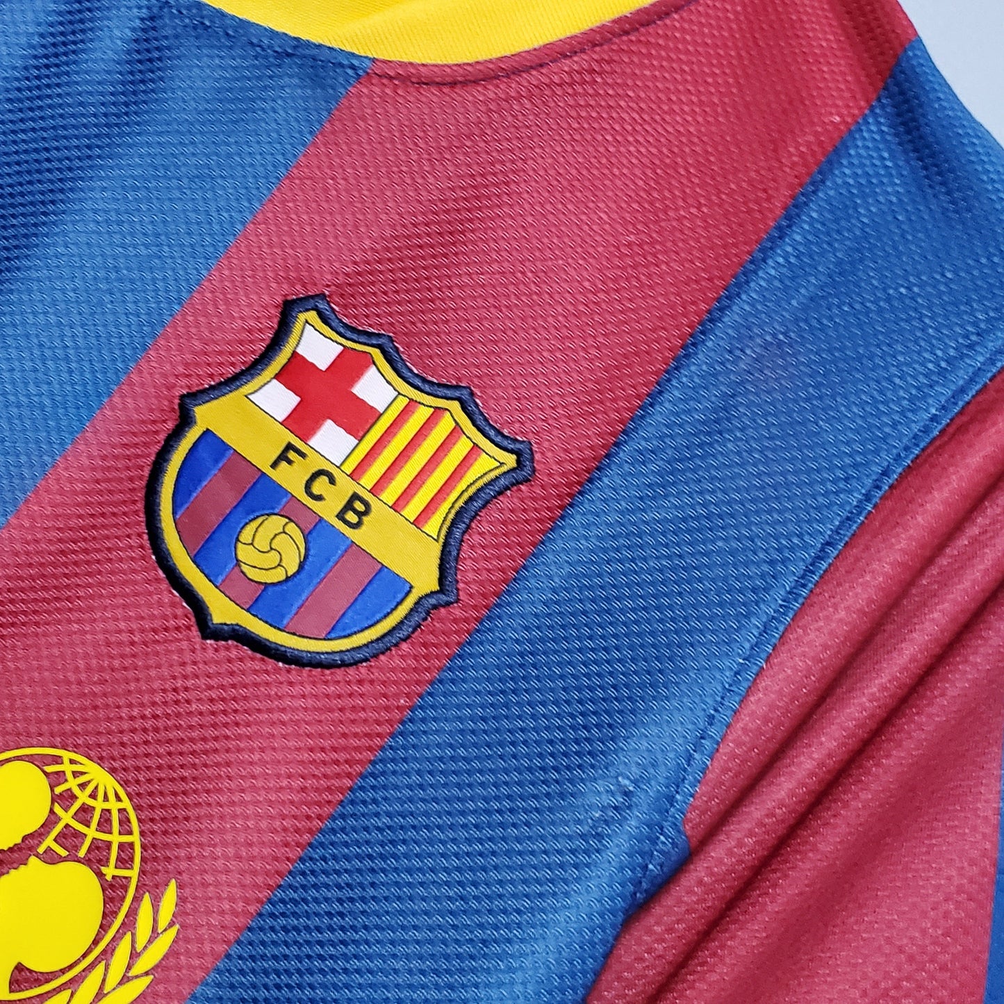 Camiseta de fútbol azulgrana con escudo FCB, temática Reino del Futbol, detalle close-up