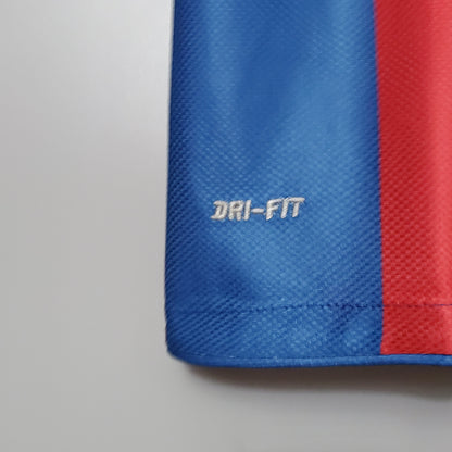 Detalle de camiseta de fútbol azul y roja con tecnología Dri-Fit, Reino del Futbol