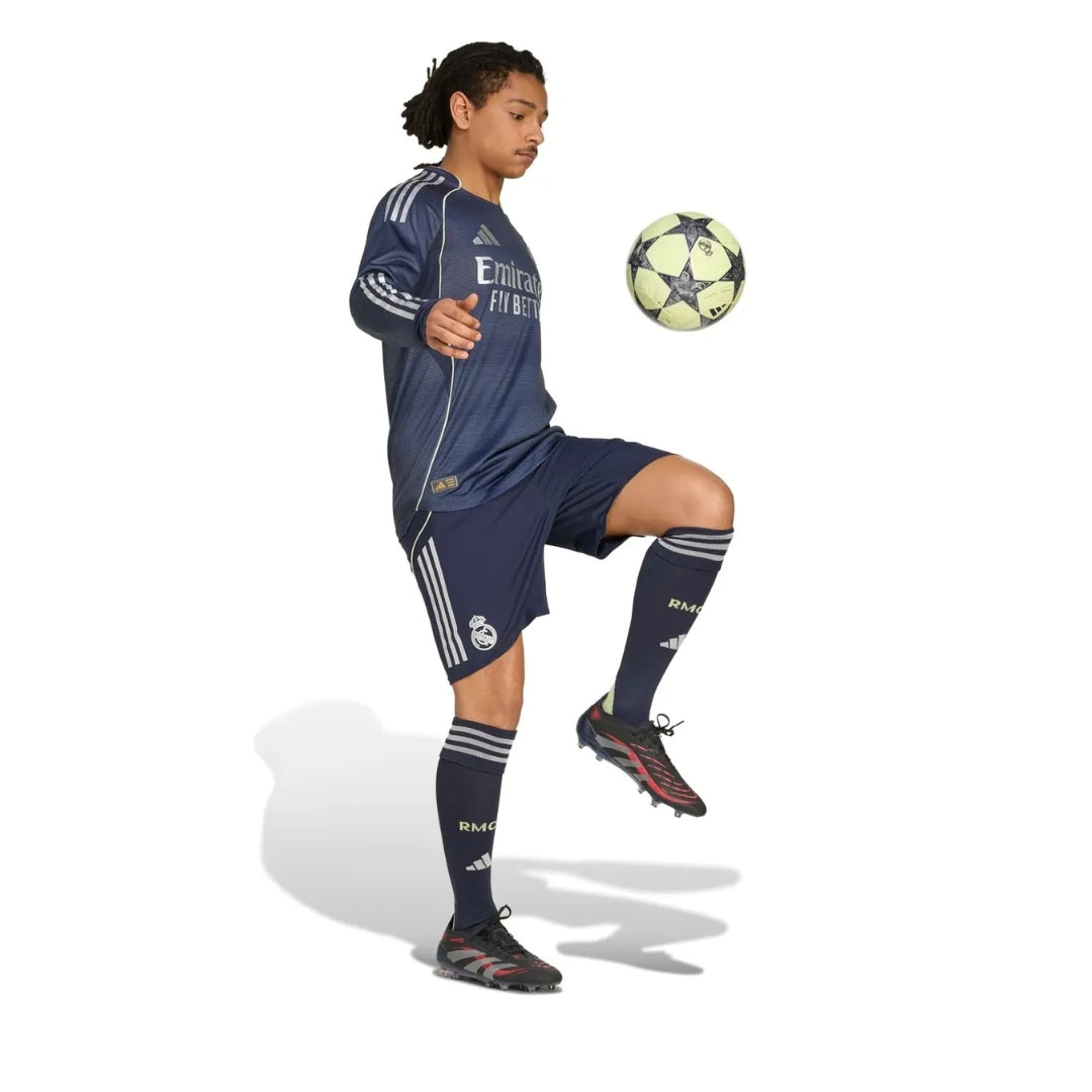 Jugador con uniforme Real Madrid 2025-2026 manga larga azul, controlando balón, Reino del Futbol