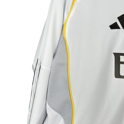 Detalle de la camiseta Real Madrid 2025 2026 manga larga blanca con líneas amarillas y negras