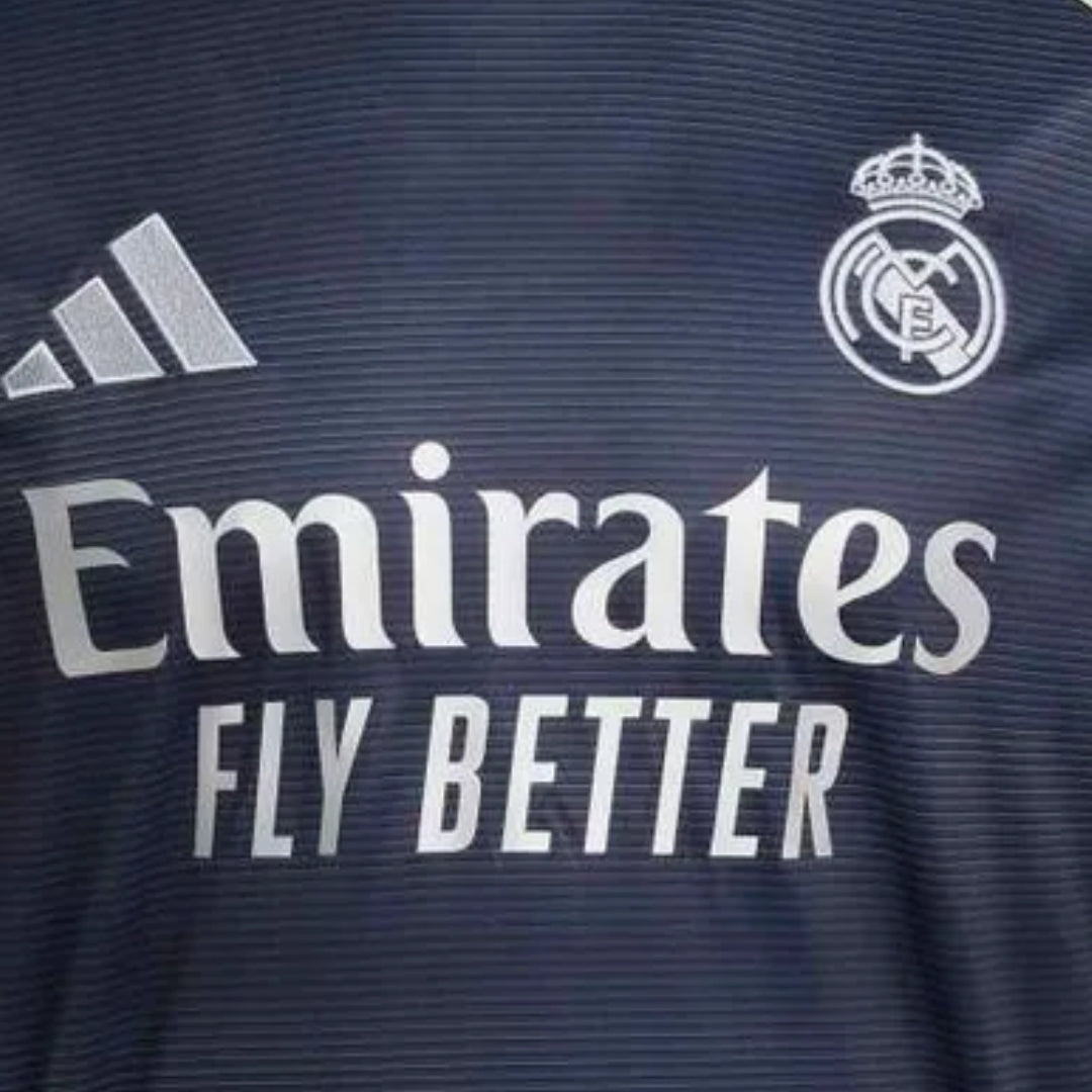 Camiseta Real Madrid azul marino 2025 con logo Adidas y escudo, patrocinador Emirates
