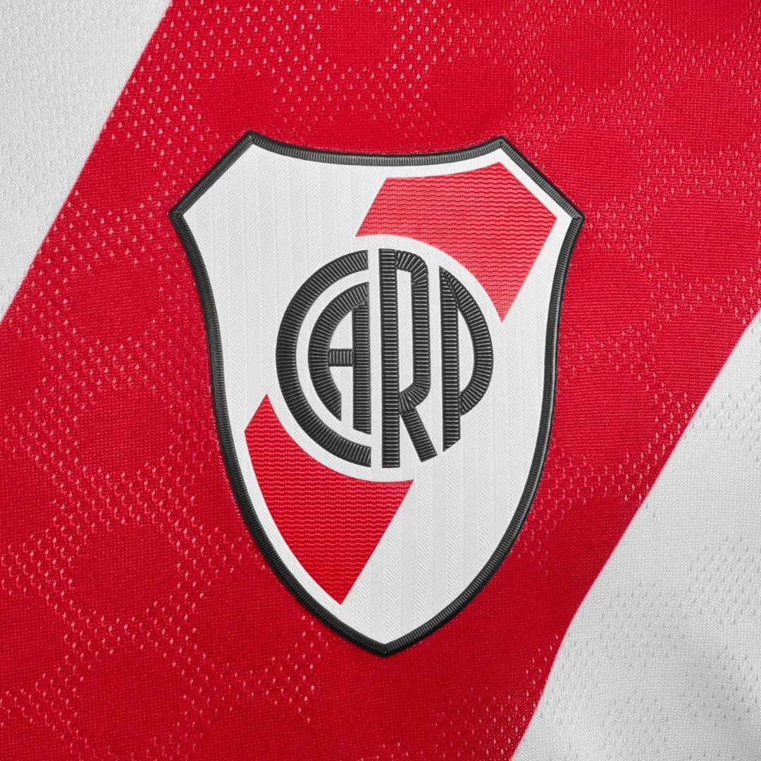 Escudo de River Plate en camiseta local 2026, fondo blanco y rojo, Reino del Futbol.