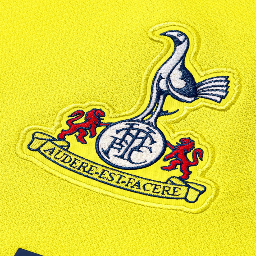 Escudo de Tottenham bordado en camiseta amarilla, detalle futbolístico Reino del Futbol