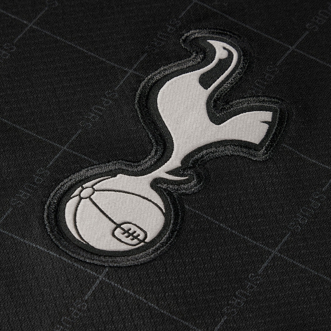 Escudo bordado Tottenham en camiseta negra, detalles visibles, Reino del Futbol