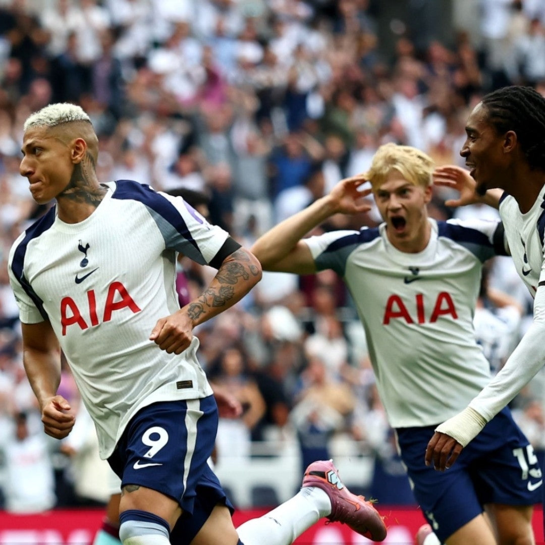 Jugadores del Tottenham celebrando gol con uniforme local en estadio lleno, Reino del Futbol