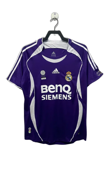 Camiseta retro Real Madrid 2006-07 visitante, morada con detalles blancos, logo adidas y escudo.