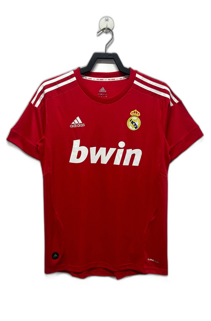Camiseta retro Real Madrid 2011-12 tercera equipación roja, logo Adidas y escudo club.