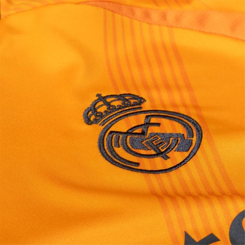 Detalle escudo Real Madrid en camiseta naranja 24/25 versión aficionado, Reino del Futbol