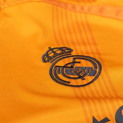 Detalle escudo Real Madrid en camiseta naranja 24/25 versión aficionado, Reino del Futbol