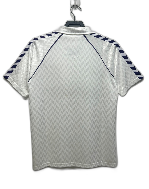 Camiseta retro Real Madrid 86-87 blanca con detalles geométricos y líneas azules en mangas
